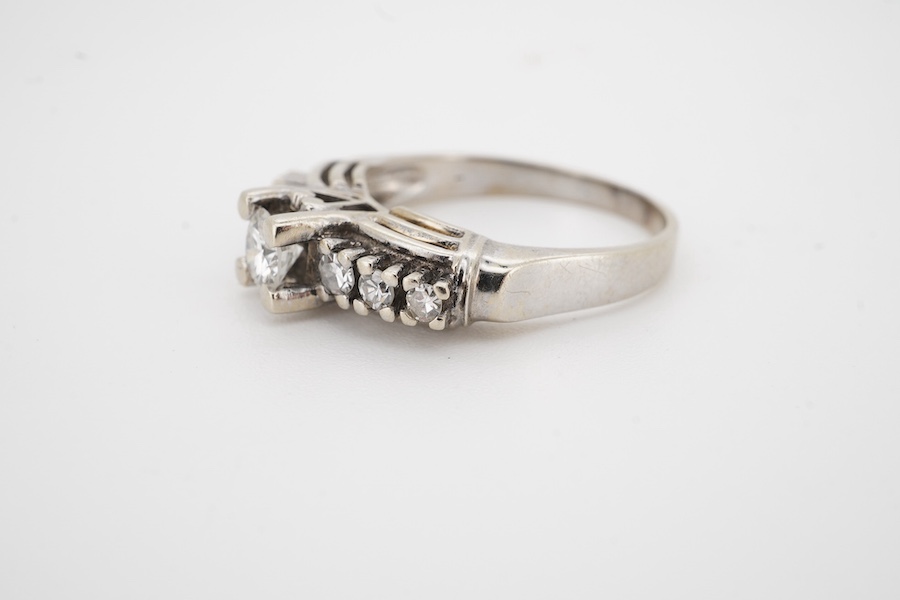 A diamond ring, set with a brilliant-cut diamond weighing approximately 0.30 carats, the shoulders set with smaller brilliant-cut diamonds totalling approximately 0.25 carats, size P, gross weight 5 grams. Condition - po